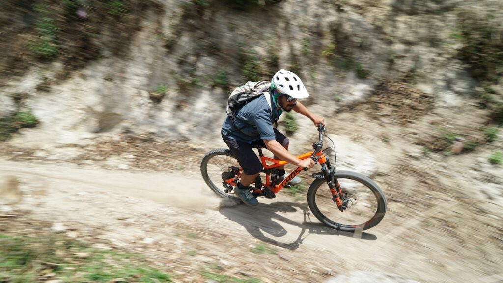 MTB rider with helmet photographed on a downhill, seen from above